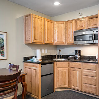 kitchenette area with dishes, pots, pans, cutlery, serve ware. dishes, drink ware. extra linens in tall closet